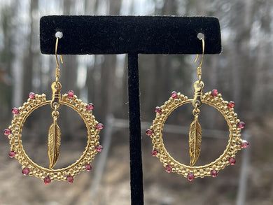 Garnet stones with size 15 gold galvanized beads and gold feather. On gold plated hooks.