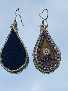 Purple and white flower teardrop moose skin earrings with seed, delica beads and 2 different banding. Backed with purple dyed fish skin. On gold plated hooks.