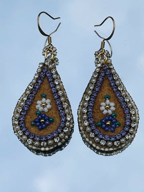 Purple and white flower teardrop moose skin earrings with seed, delica beads and 2 different banding. Backed with purple dyed fish skin. On gold plated hooks.