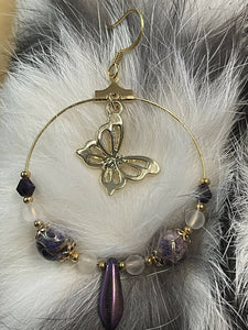 Gold butterfly hoop earring with purple and gold cloisonné round beads and gold bead caps, matte crystal quartz, Australian crystals, purple iris daggers and 24k gold seed beads. On gold filled hooks.